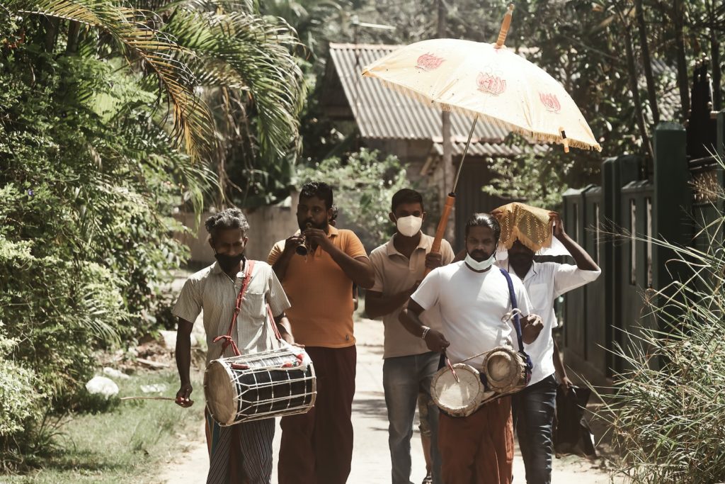 a group of men walking down a dirt road