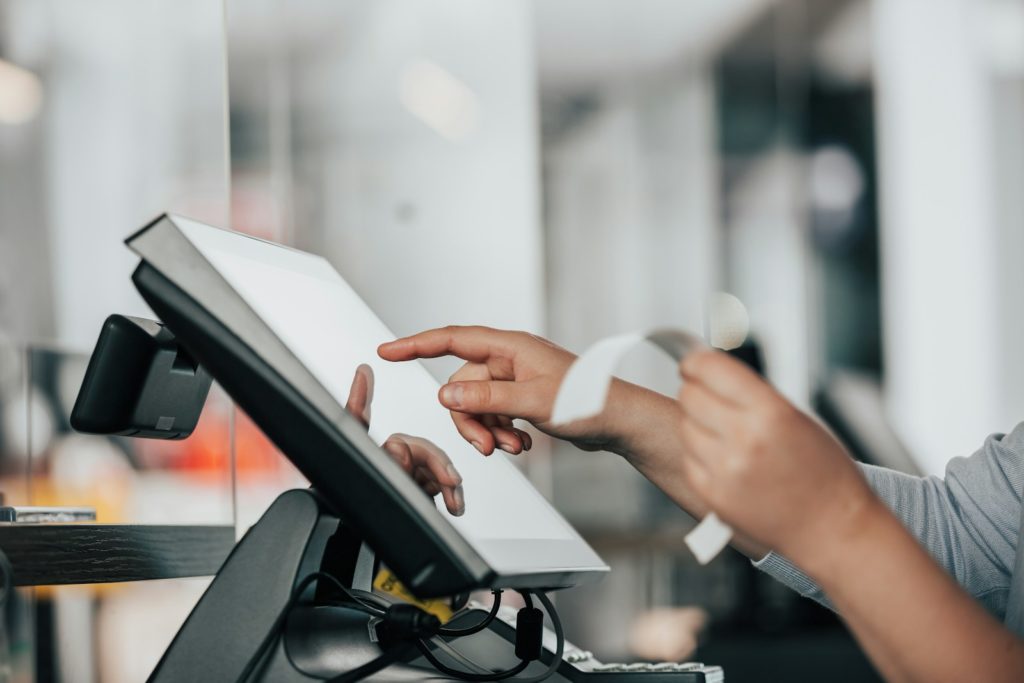 una persona sta utilizzando una macchina pos in un negozio